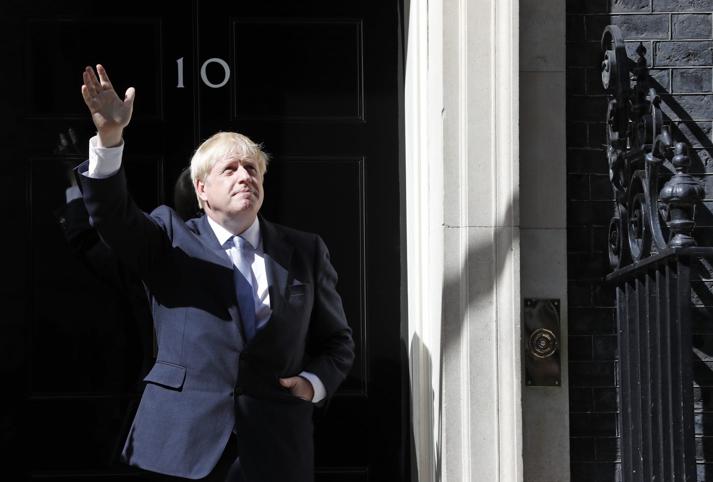 Britain's new Prime Minister Boris Johnson waves from the steps outside 10 Downing Street on July 24, 2019. (AP Photo/Frank Augstein)