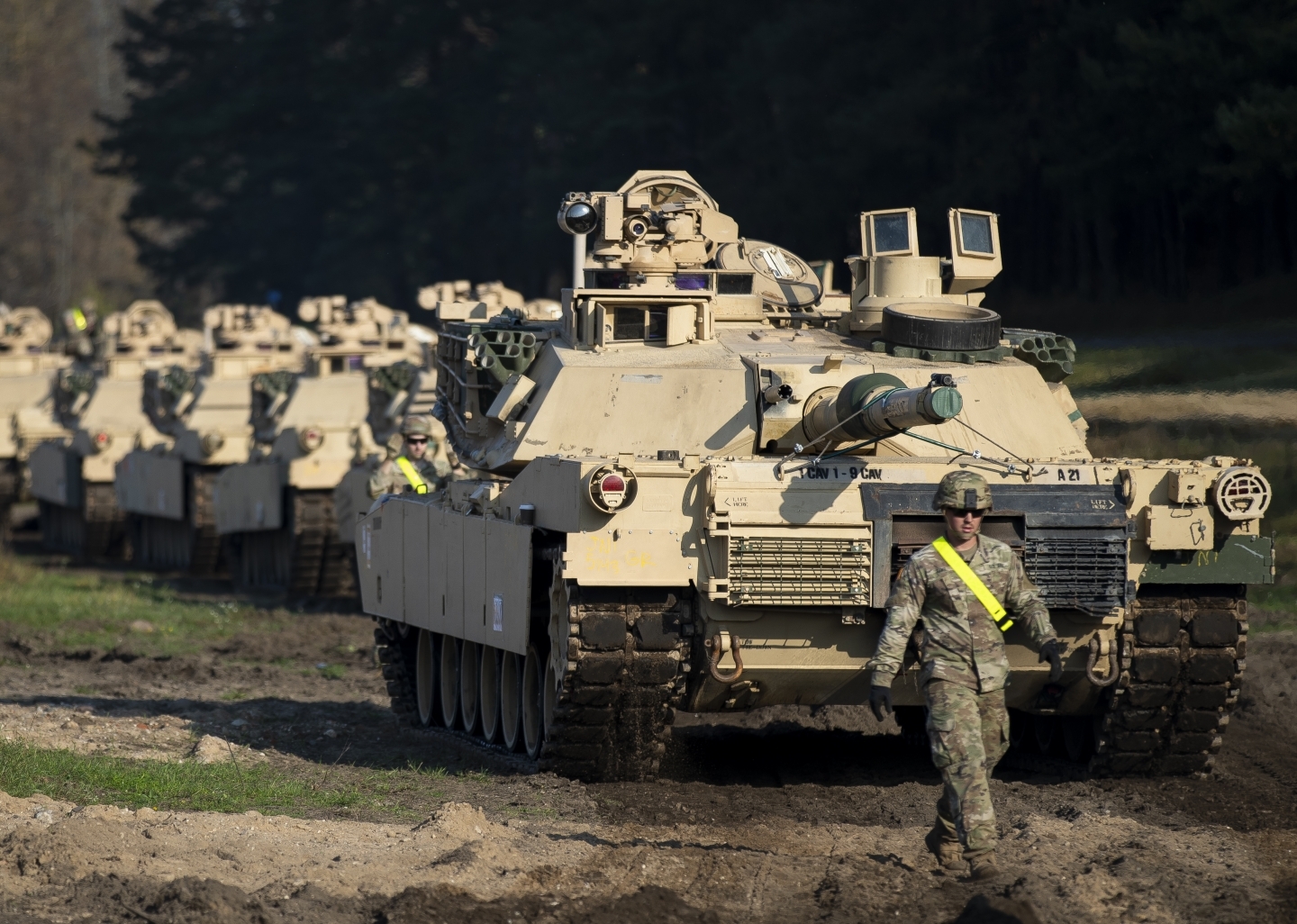 A member of the US Army's 1st Armoured Battalion of the 9th Regiment, 1st Division walks near Abrams battle tanks. (AP Photo/Mindaugas Kulbis)
