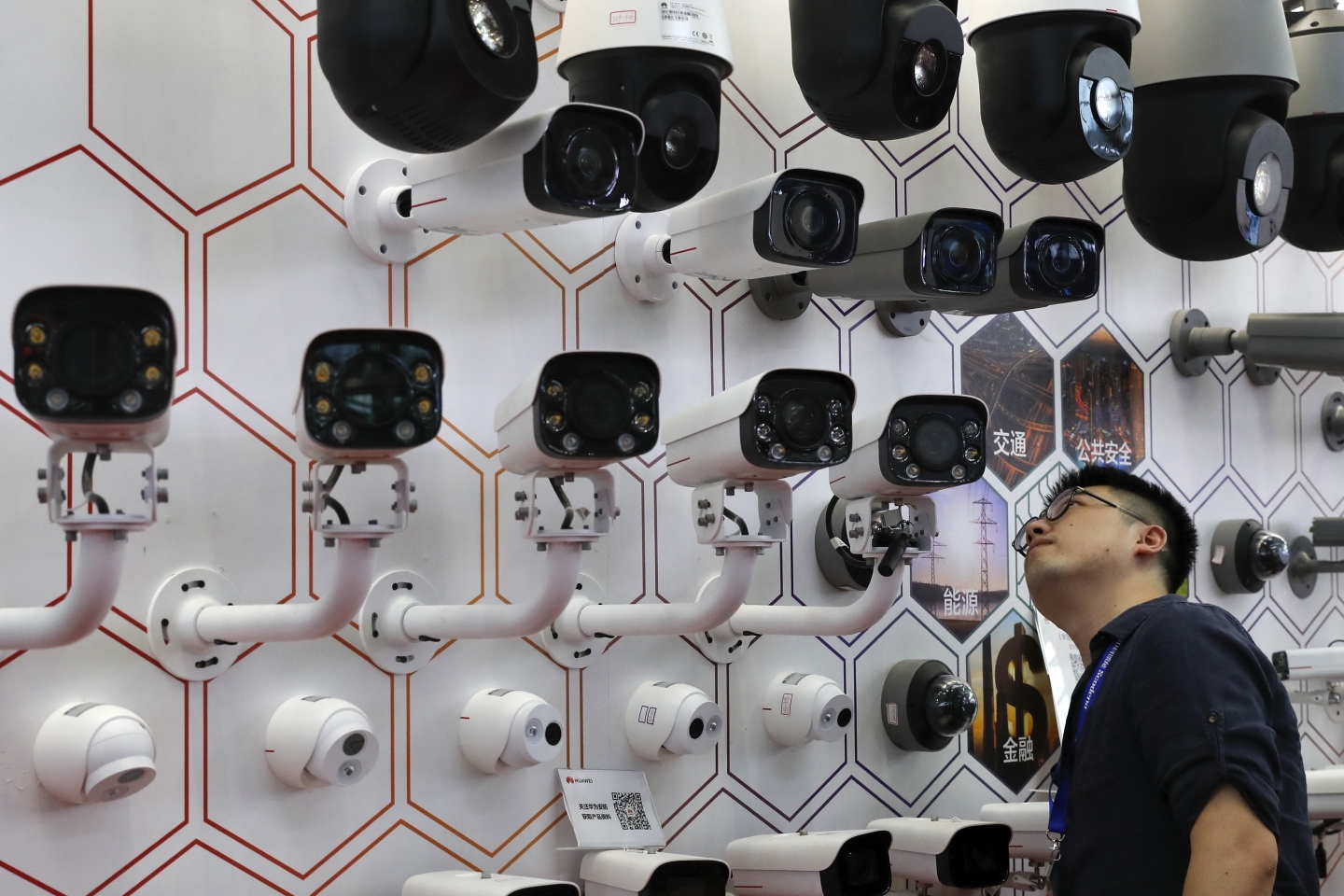 A man takes a closer look at the surveillance cameras on display at the China Public Security Expo in Shenzhen, China on October 29, 2019. (AP Photo/Andy Wong)