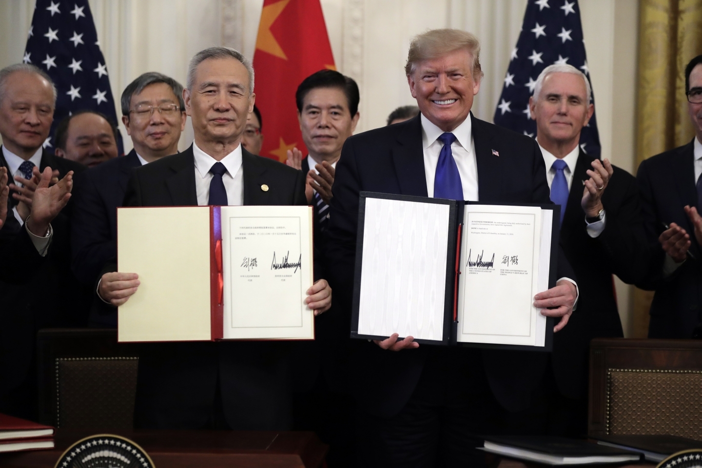 U.S. President Donald Trump, right, signs a trade agreement with Chinese Vice Premier Liu He. (AP Photo/Evan Vucci)