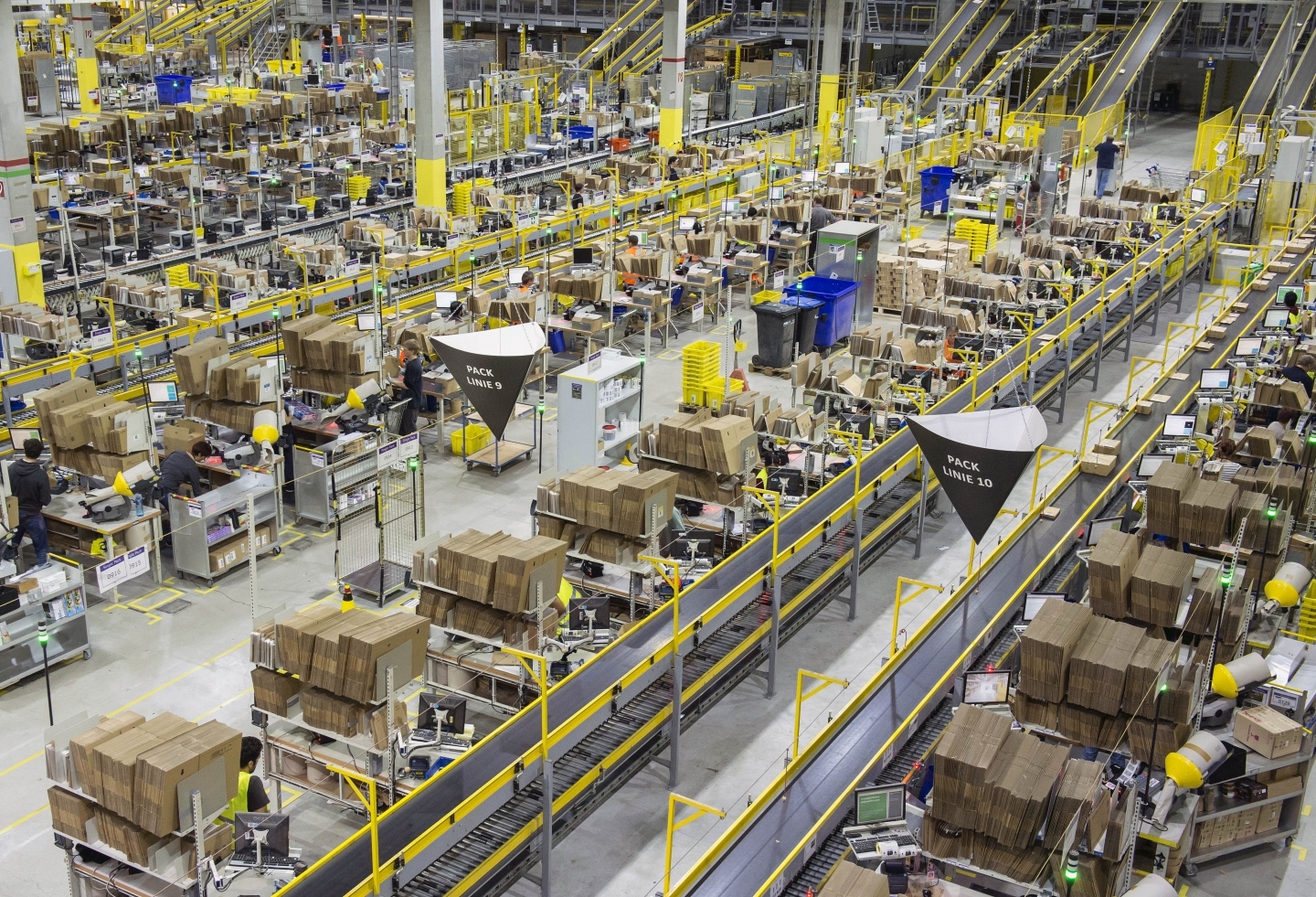 Artificial intelligence and people work side by side in an Amazon distribution centre. (AP Photo/Jens Meyer)