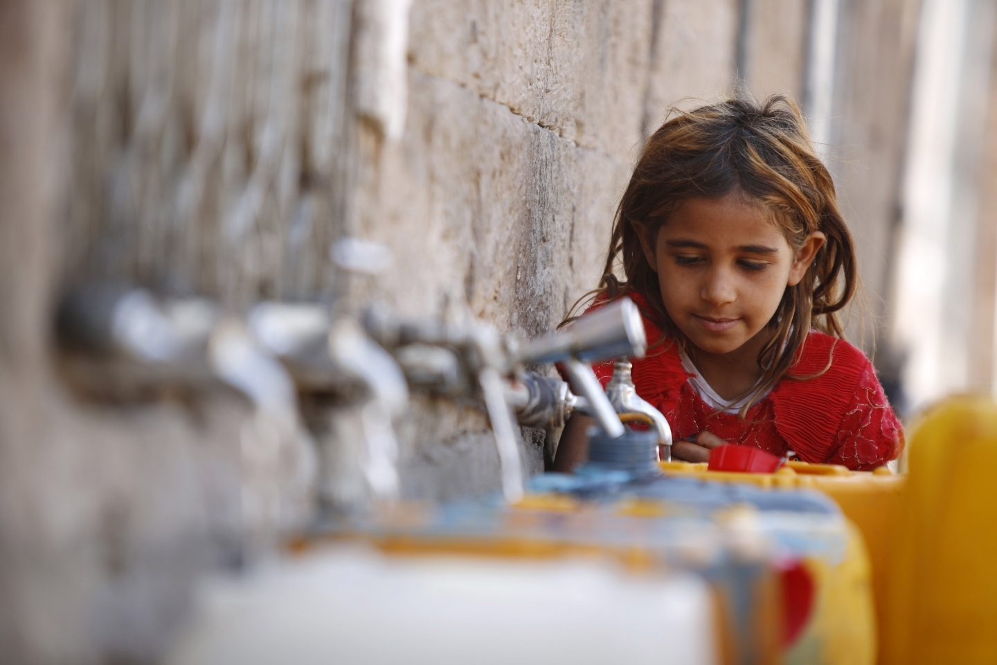 A girl fills a container with water from a public tap in the old city of Sanaa, Yemen (AP Photo/Hani Mohammed)