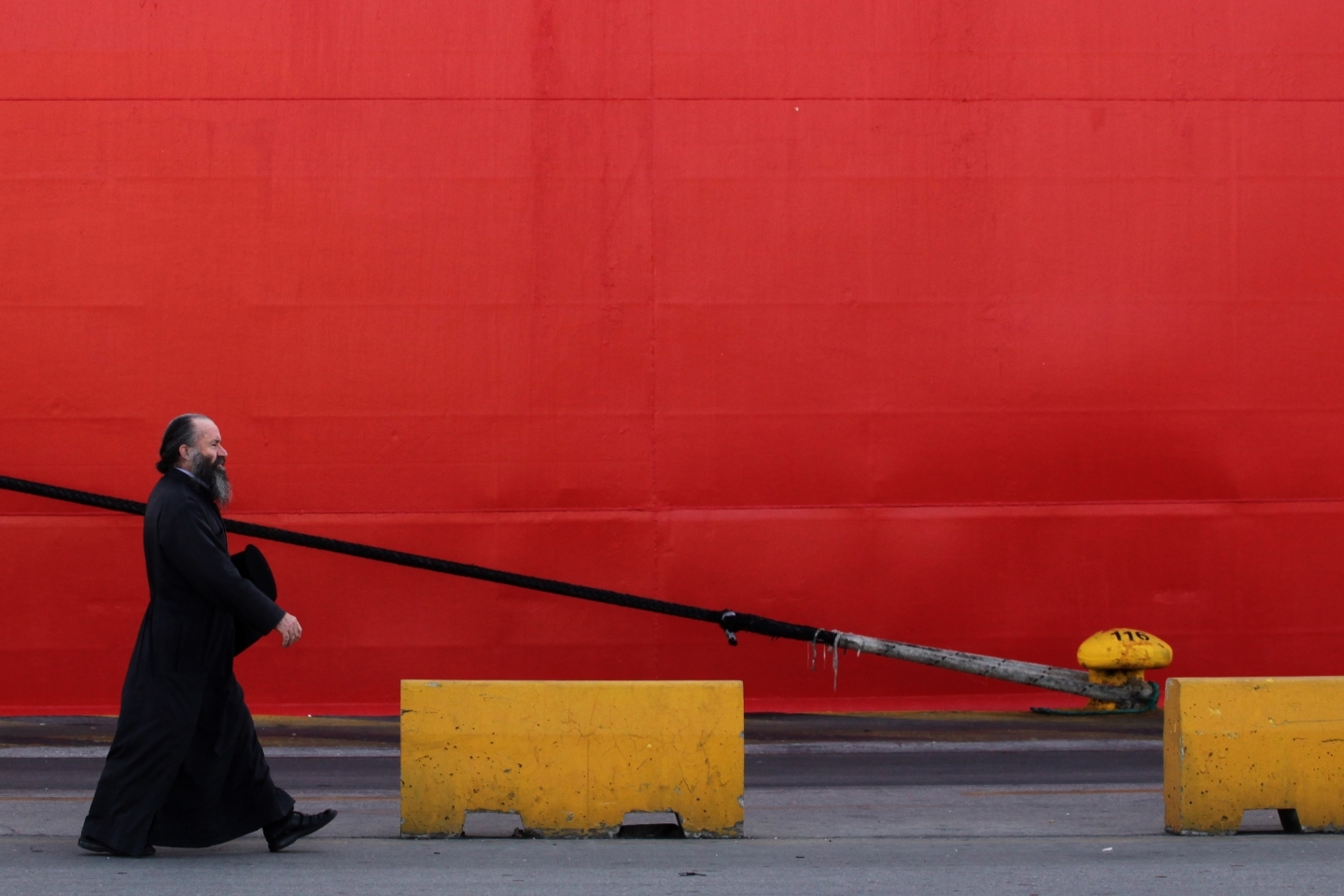 A Greek orthodox priest passes a docked ship during a general strike against austerity (AP Photo/Petros Giannakouris)