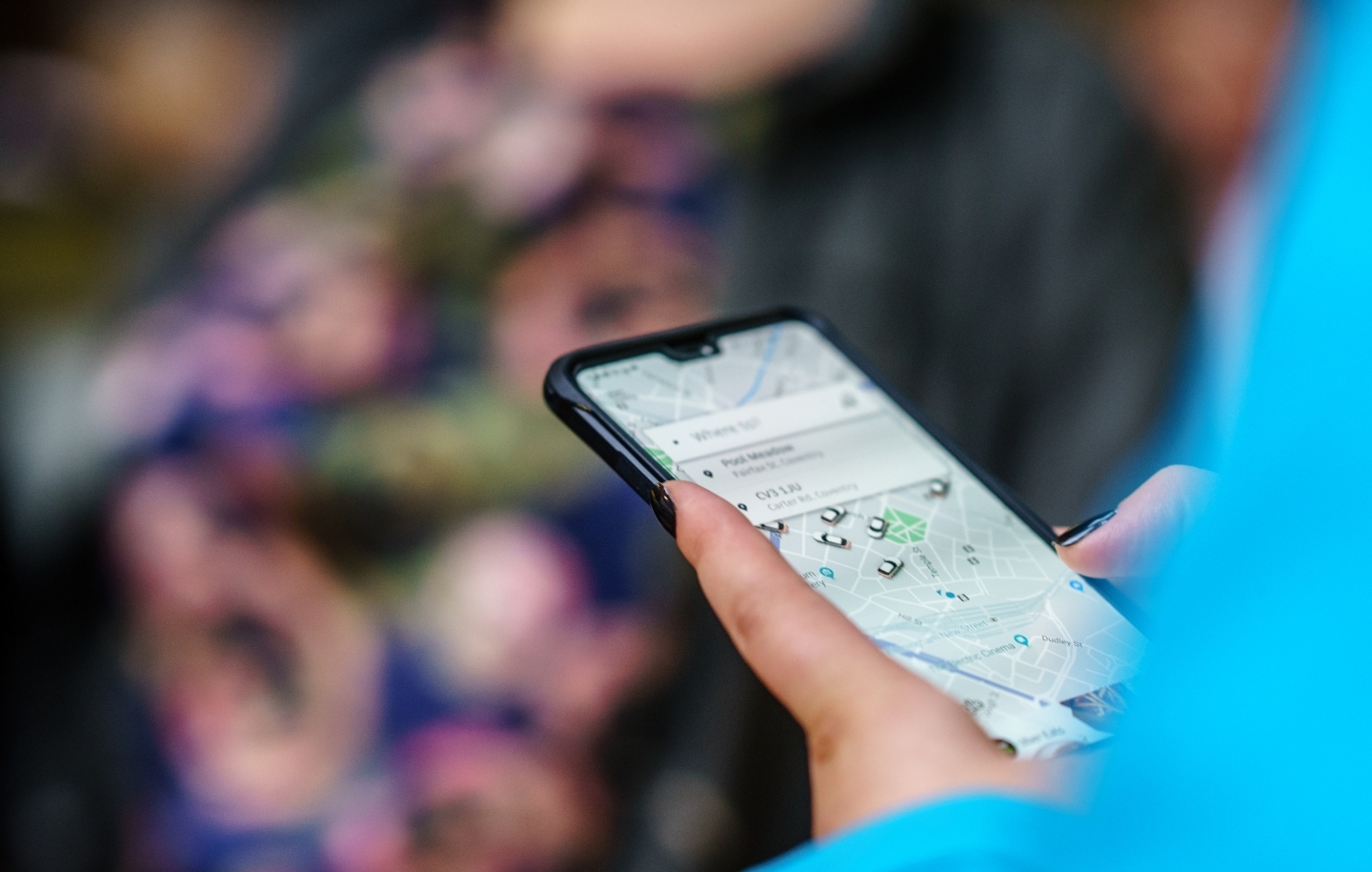 A person hails a driver using the Uber app. (Shutterstock)