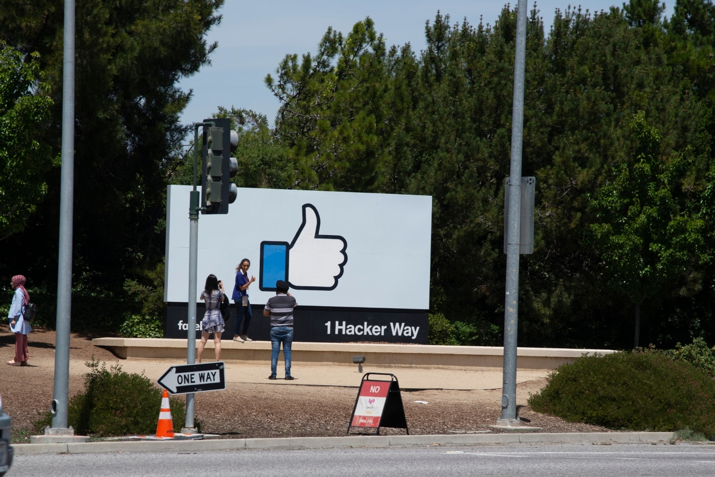 Passersby take photos with the sign at Facebook's headquarters. (Shutterstock)