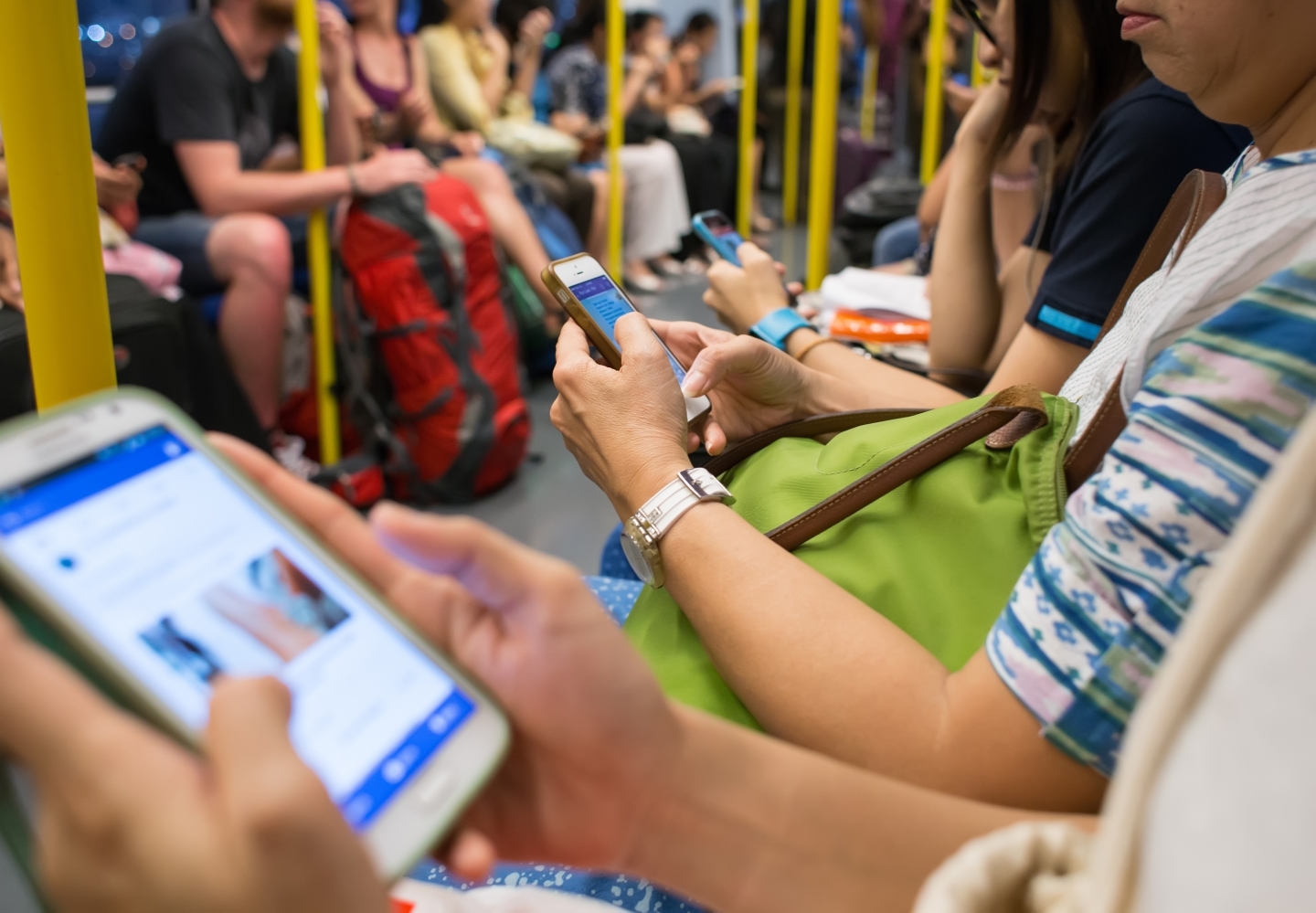 Unknown people uses mobile phone while travel by subway. (Shutterstock)