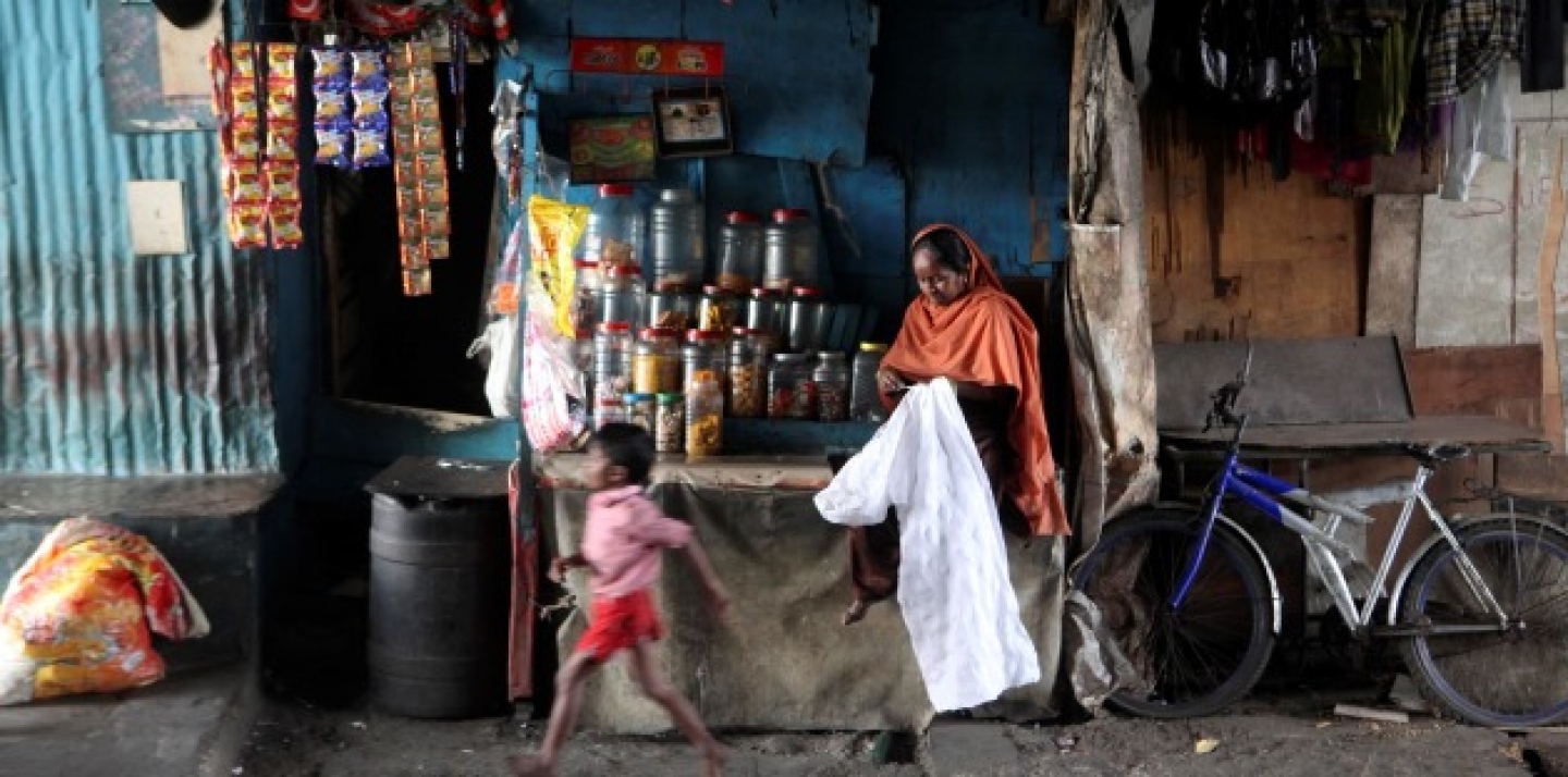 Indian woman Amina Shah, a microfinance beneficiary, stitches a shirt as she waits for customers at her shop in a slum in Mumbai, India, Monday, March 7, 2011. (AP Photo/Rafiq Maqbool)