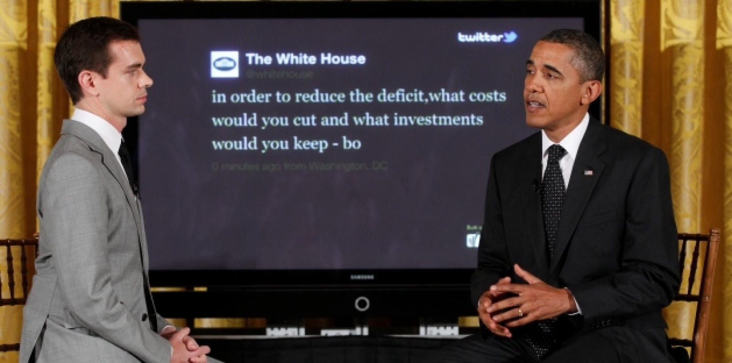 President Barack Obama sits with Twitter co-founder and Executive Chairman Jack Dorsey in front of a screen displaying the question he tweeted during a "Twitter Town Hall" (AP Photo/Charles Dharapak).