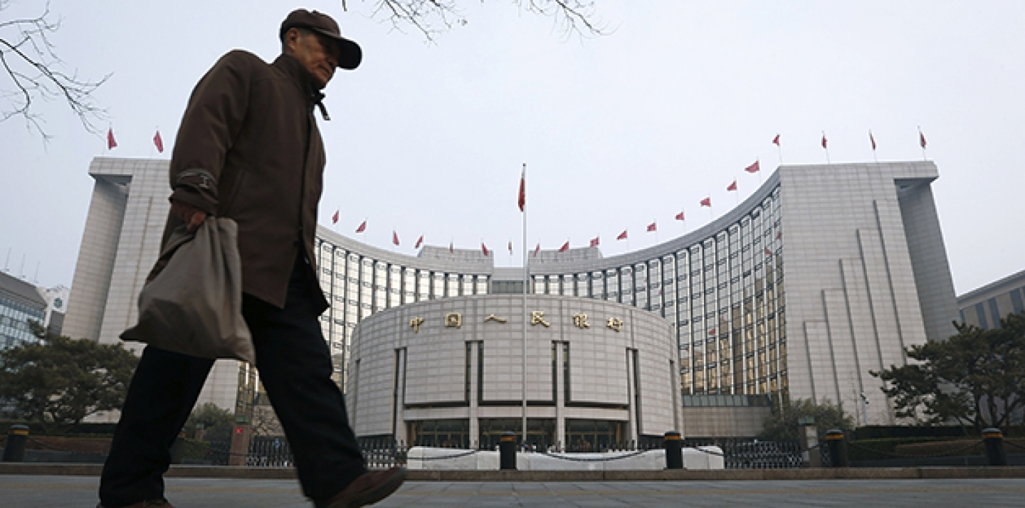 An elderly Chinese man walks past the headquarters of the People's Bank of China (PBOC) in Beijing, China. (AP Photo/Vincent Thian)