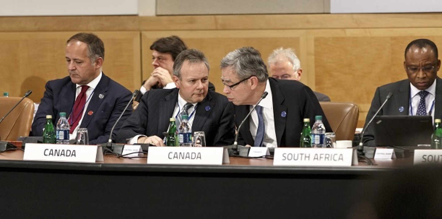 Canada's former finance minister, Joe Oliver, center right, leans in to speak with Stephen Poloz, governor of the Bank of Canada, center left, as the Group of Twenty nations gather at the International Monetary Fund and World Bank meetings in Washington, Friday, Oct. 10, 2014.(AP Photo/J. Scott Applewhite)
