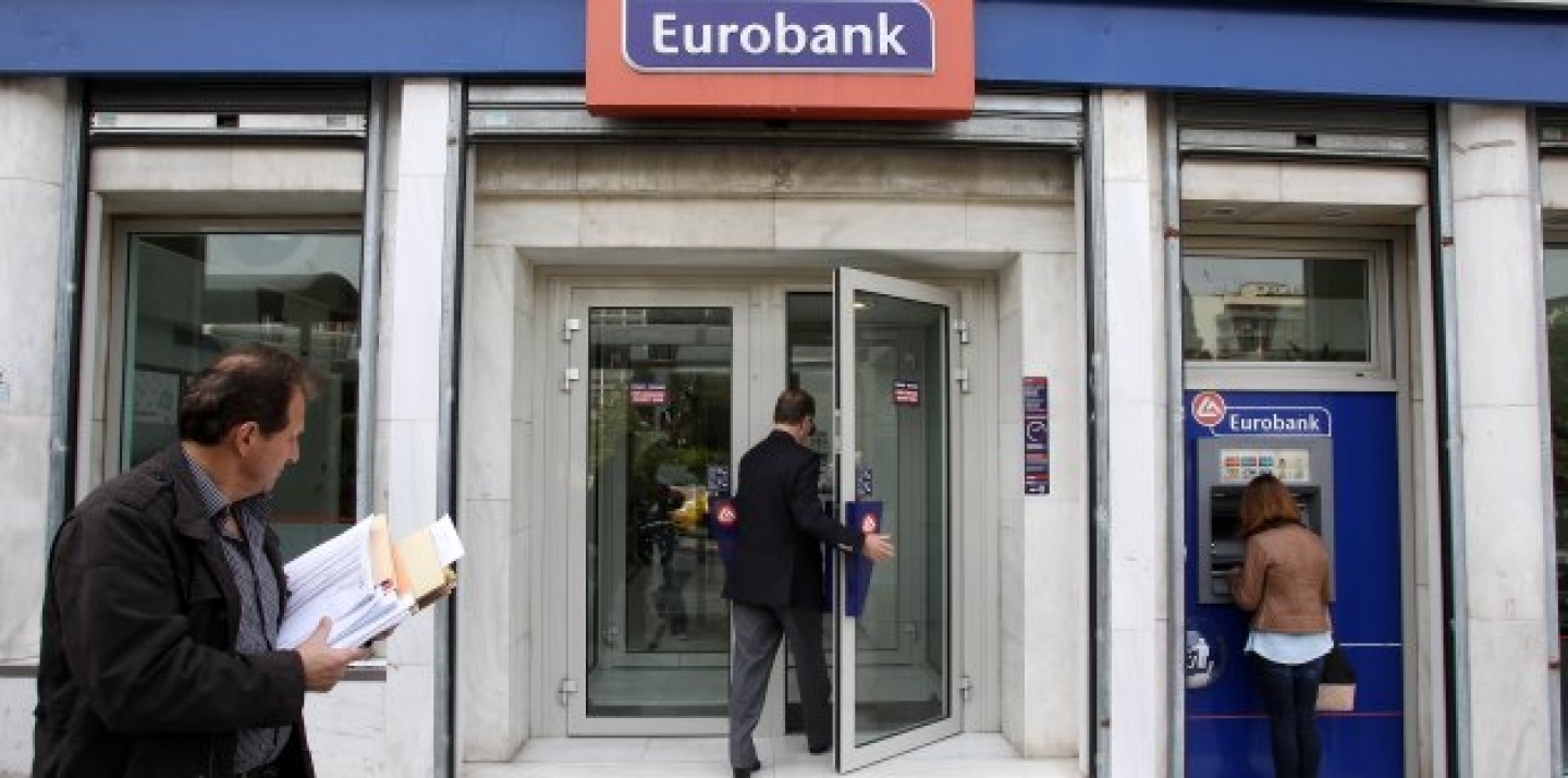 Customers use the ATM and enter a branch of Eurobank in central Athens. (AP Photo/Thanassis Stavrakis)