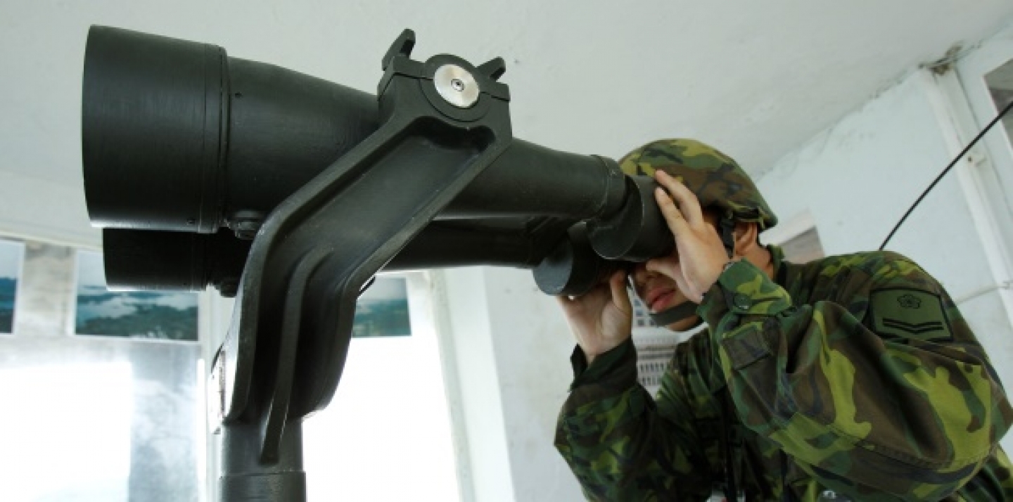 A Taiwanese soldier peers through binoculars towards China just 1.8 kilometers from his frontline pillbox. (AP Photo/Wally Santana)