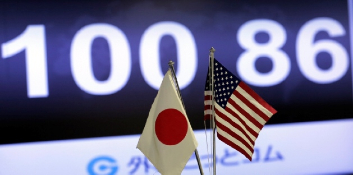 The exchange rate of the U.S. dollar against Japanese yen is shown behind both countries' flags at an exchange in Tokyo, Friday, May 10, 2013. The yen broke the the psychologically important 100 yen to the dollar mark. (AP Photo/Itsuo Inouye)