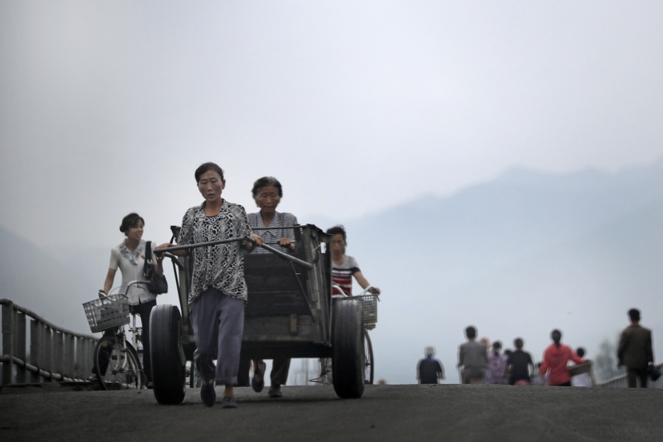 North Korean women push their cart and bicycles over a bridge onJuly 21, 2017, in Hamhung, North Korea. Hamhung is the second largest city and the capital of South Hamgyong Province in North Korea. (AP Photo/Wong Maye-E)