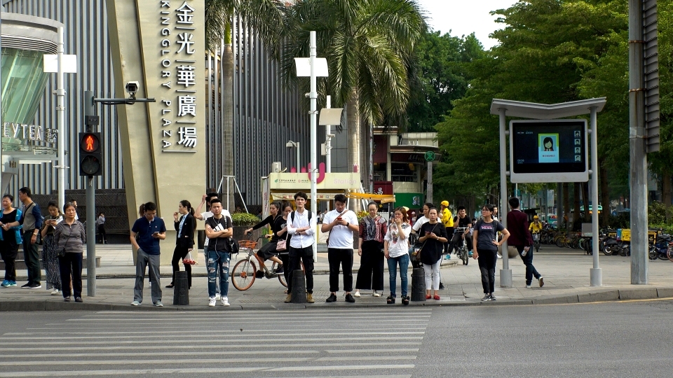 Facial recognition technology is used at an intersection to identify jaywalkers in Shenzen, China. Offenders' faces are often displayed on the screen. (Shutterstock).