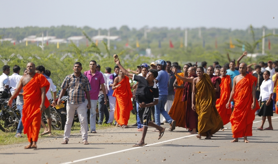 A Sri Lankan protester hurls a stone at government supporters during a protest in Ambalantota, Sri Lanka. The government has signed a framework agreement for a 99-year lease of the Hambantota Port. (AP Photo/Eranga Jayawardena)