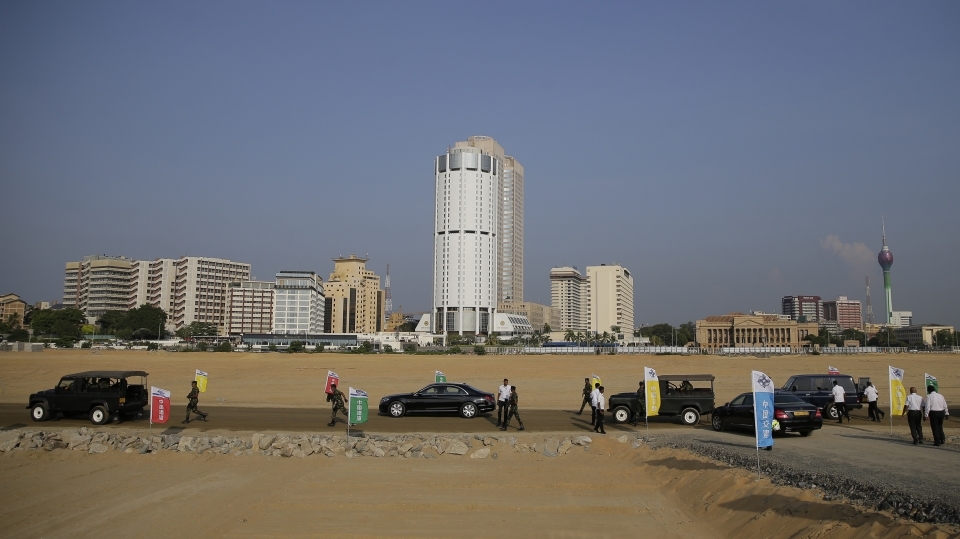 Visitors walk through a plot of land off the coast of Colombo, Sri Lanka that was reclaimed from the ocean as part of the Belt and Road Initiative. (AP Photo/Eranga Jayawardena)