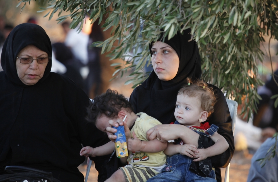 Newly-arrived Syrian refugees rest after crossing the border from Tal Shehab, Syria, into Thnebeh town, in Ramtha, Jordan on September 5, 2012. (AP Photo/Mohammad Hannon)