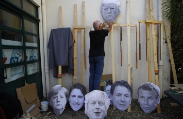 A man fixes an image of President Donald Trump to a wooden pole as he prepares for an anti-G7 demonstration at a camp near Hendaye, France. (AP Photo/Francois Mori)